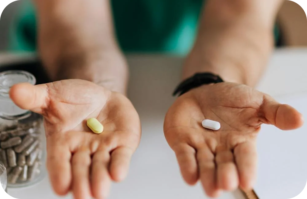 A healthcare professional presenting two pills, highlighting their role in medical therapy.