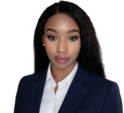 A woman with long black hair wearing a brown jacket stands confidently, showcasing her style and poise.